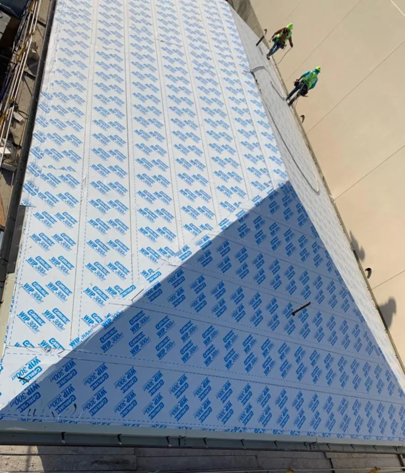 Professional roofers installing underlayment on a metal roof in East Huntingdon